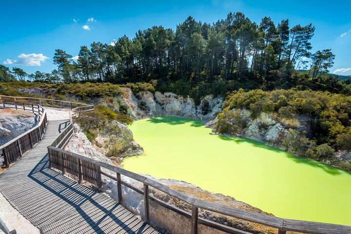 Immerse yourself in the otherworldly beauty of Devil's Bath where striking green waters contrast with the rugged landscape creating a unique experience of New Zealand's geothermal wonders.